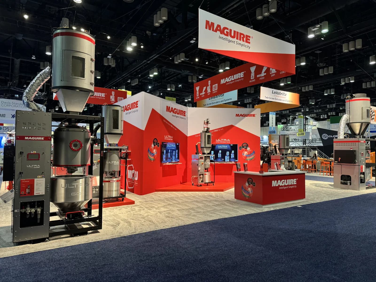 Angled view of a red-and-white equipment exhibit with tall product displays.