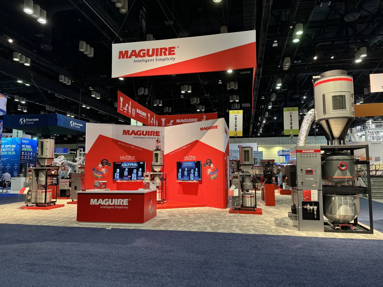 Open red-and-white exhibit centered on machinery, counters, and suspended signage.