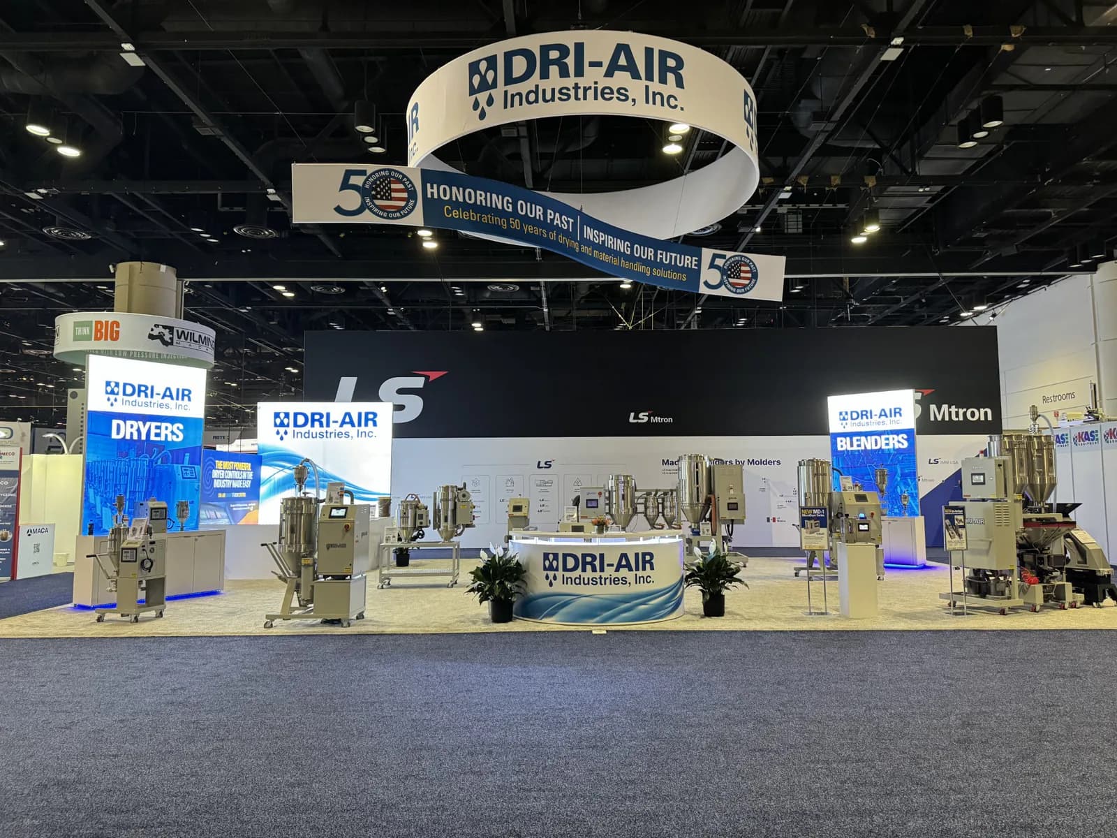 Wide blue-and-white machinery exhibit beneath circular overhead signage.
