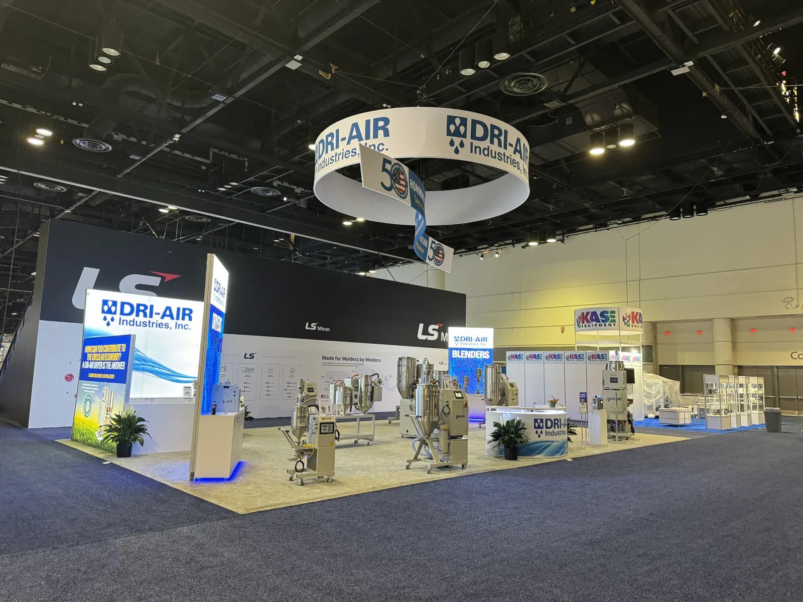 Bright equipment exhibit with open corner access and suspended circular signage.